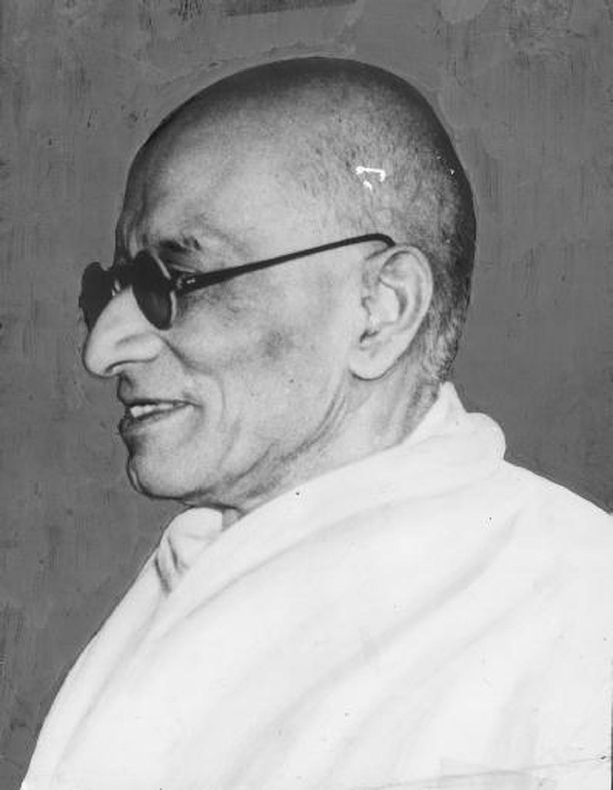 Profile portrait of C. Rajagopalachari in dark round glasses and a khadi shawl.